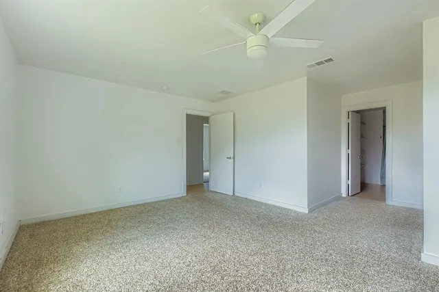 a view of an empty room and a ceiling fan