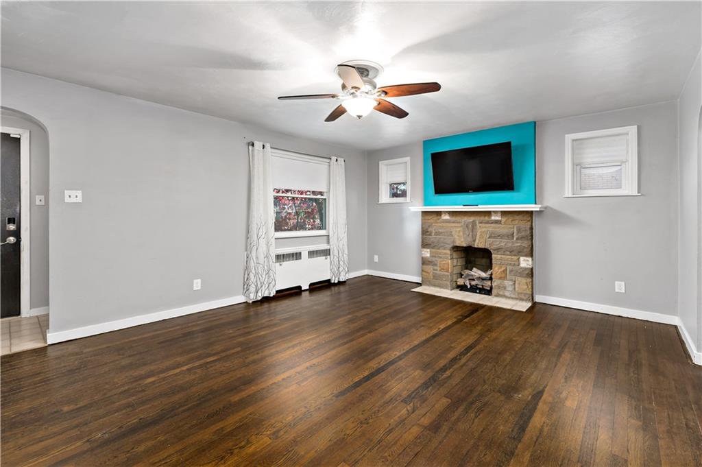 425 MacArthur Street McKees Rocks, PA 15136 - Photo 3 of 25 a view of a livingroom with a fireplace a ceiling fan and wooden floor
