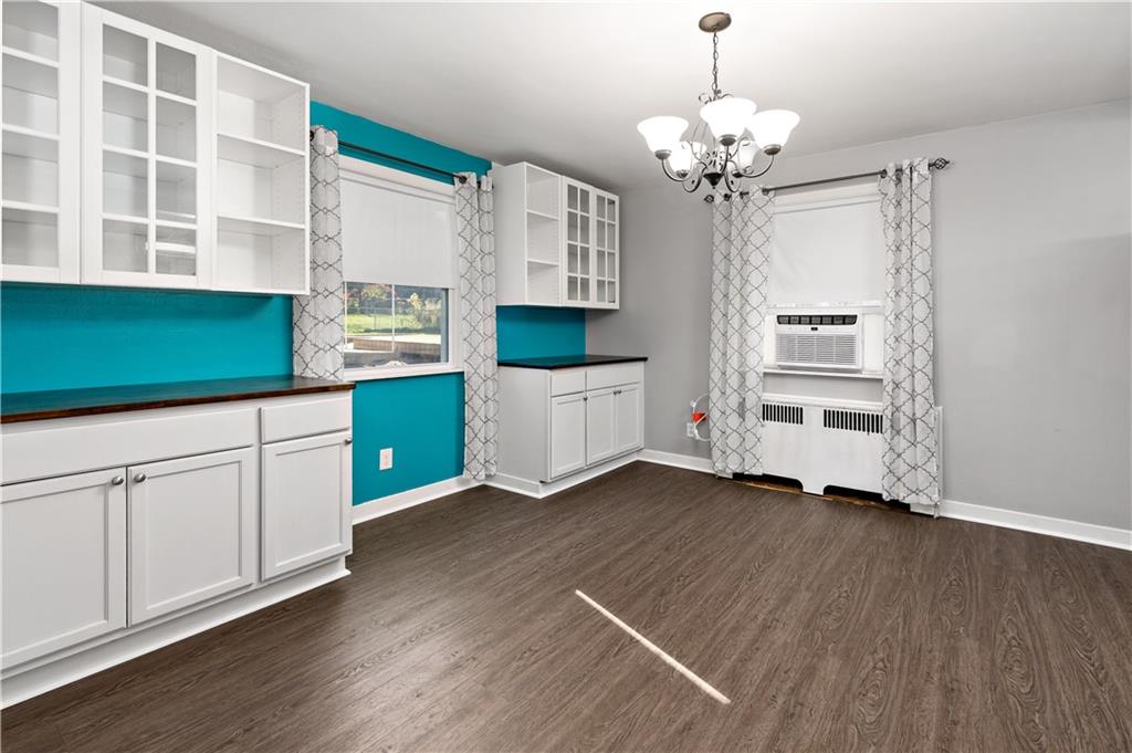 425 MacArthur Street McKees Rocks, PA 15136 - Photo 8 of 25 a kitchen with a wooden floor and white cabinets