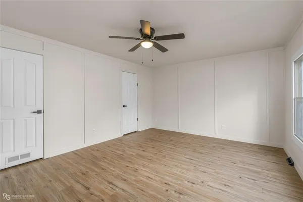 a view of empty room with wooden floor