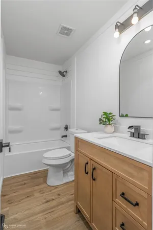 a bathroom with a granite countertop toilet sink and mirror