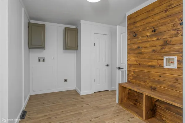 a view of an empty room with wooden floor and cabinet