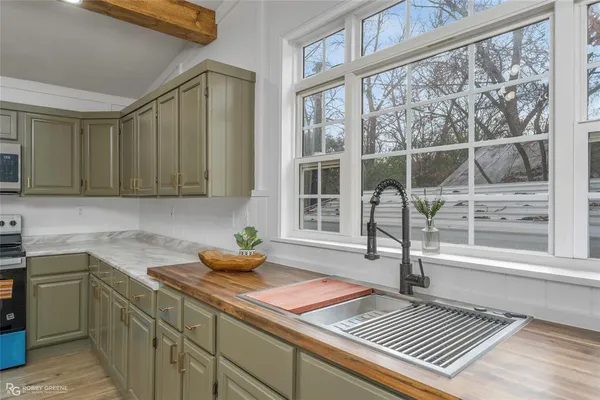 a kitchen with a sink a counter top space and stainless steel appliances