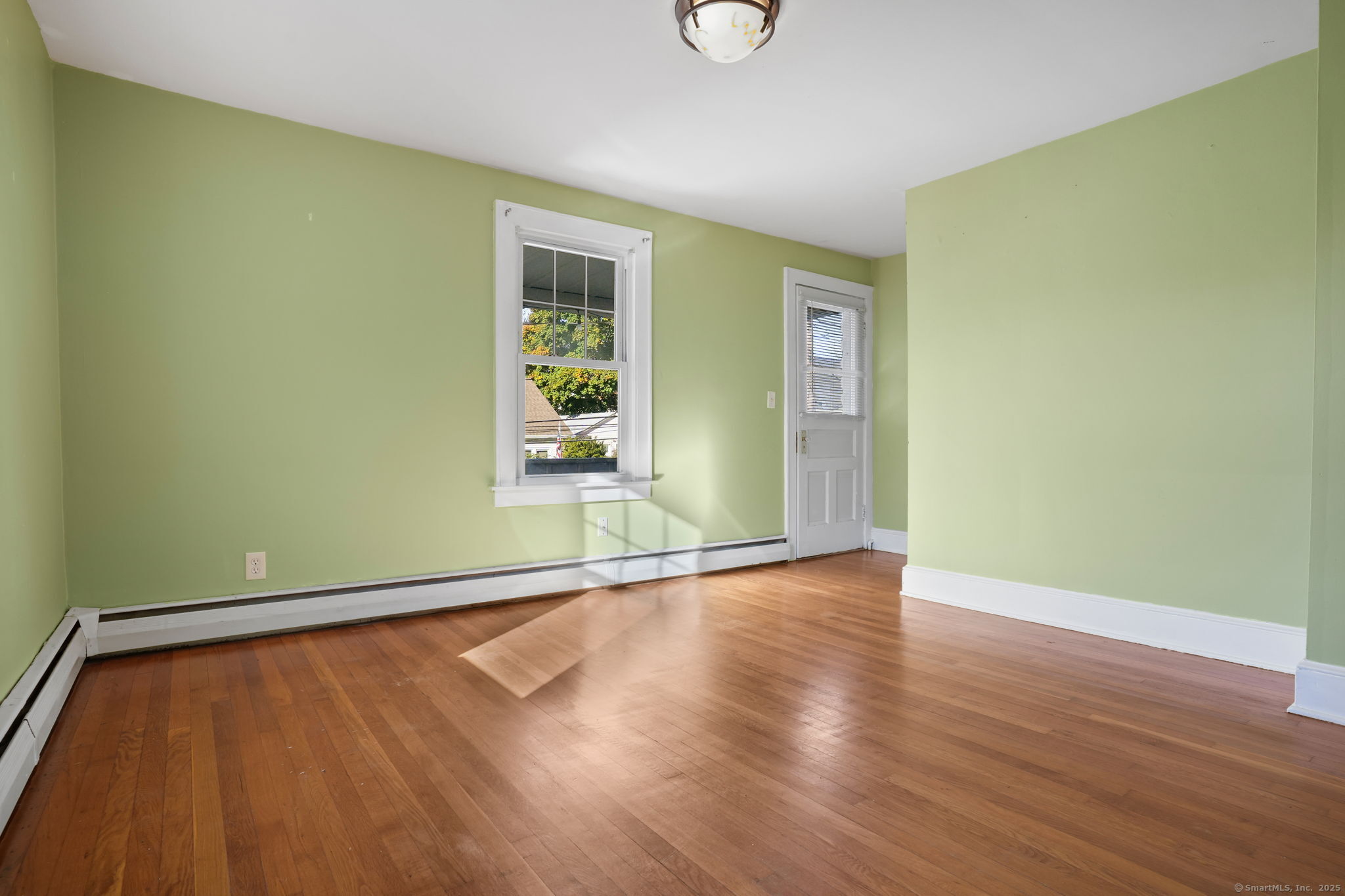 117 Golden Hill Street Naugatuck, CT 06770 - Photo 2 of 10 an empty room with wooden floor and windows