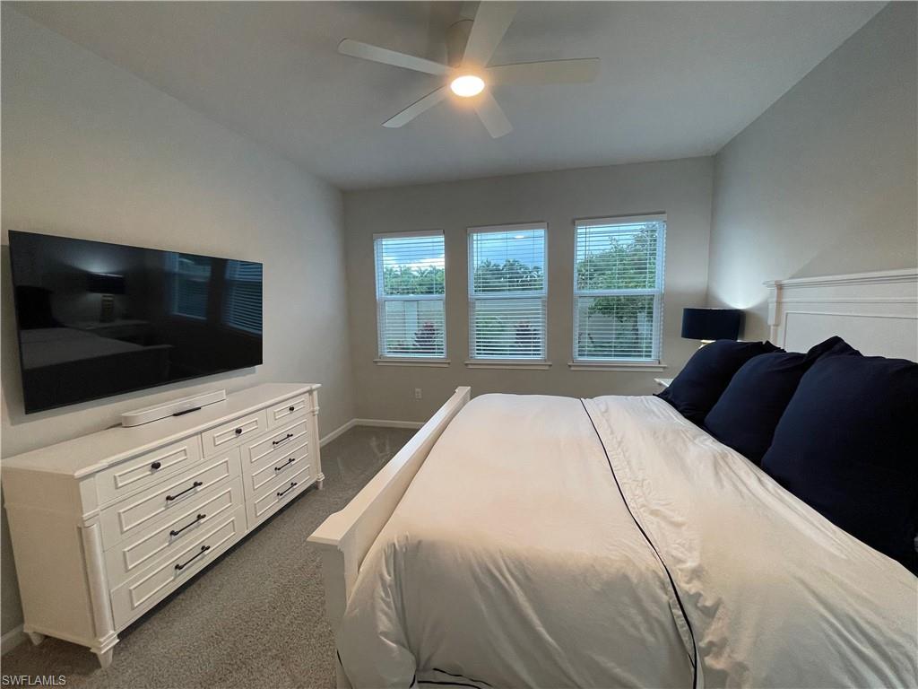 4676 Arboretum Circle, Unit 101 Naples, FL 34112 - Photo 12 of 24 a bedroom with a large bed and a flat screen tv
