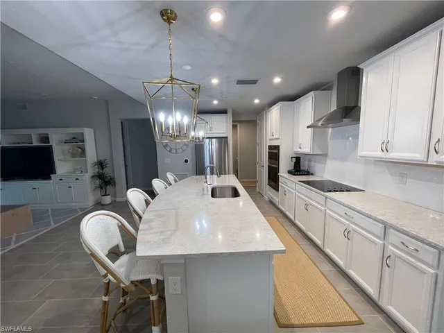 a large kitchen with stainless steel appliances kitchen island granite countertop a sink a stove a dining table and chairs