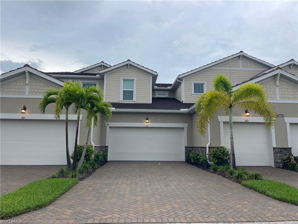 4676 Arboretum Circle, Unit 101 Naples, FL 34112 - Photo 5 of 24 a front view of a house with a yard and garage