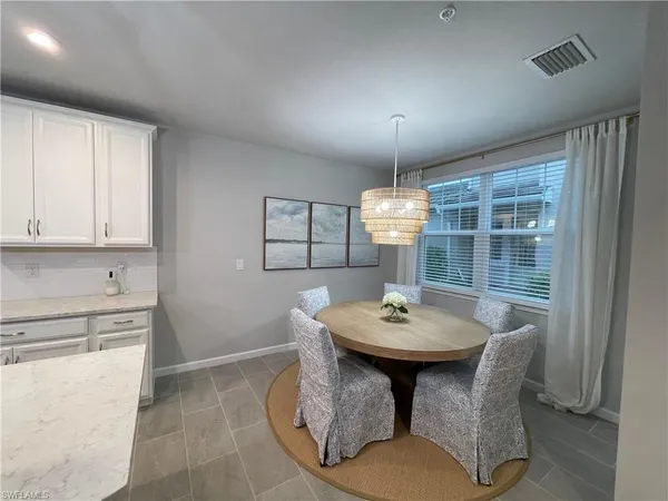 a dining room with furniture a chandelier and window