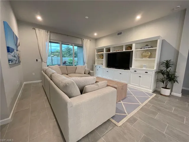 a living room with furniture a large window and a flat screen tv
