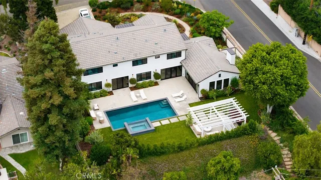 a view of a house with swimming pool and trees in front of it