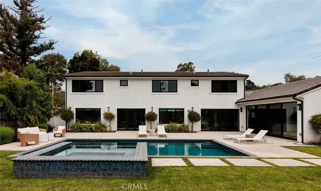 a view of a house with swimming pool and sitting area
