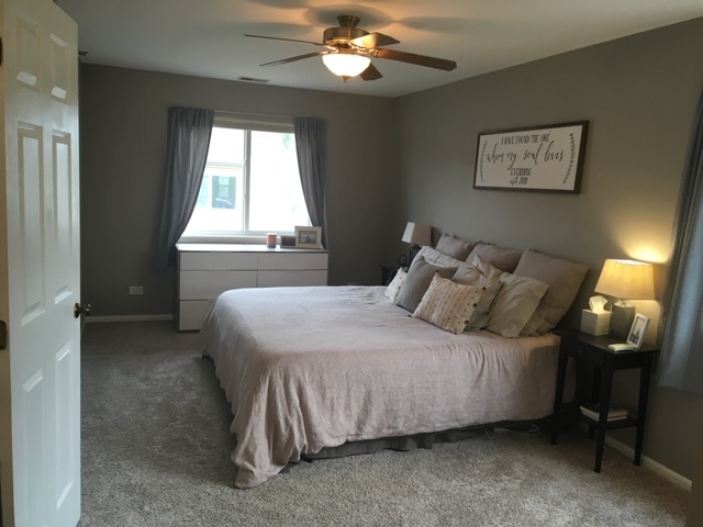 Undisclosed Address Palatine, IL 60074 - Photo 8 of 10 a bedroom with a bed and a chandelier