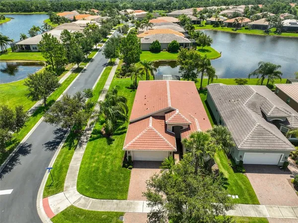 an aerial view of a house with a garden and lake view