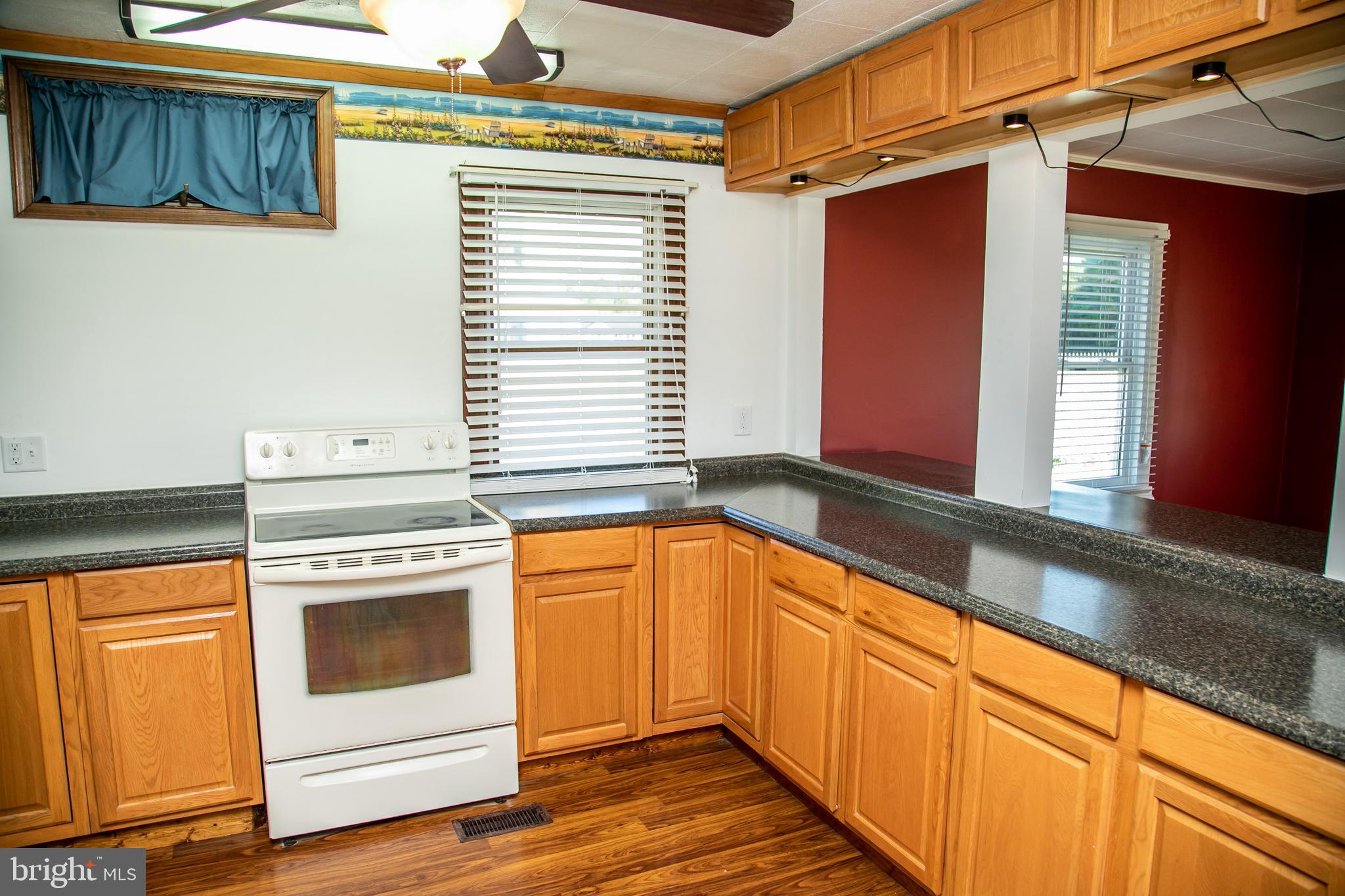 20135 Nanticoke Road Nanticoke, MD 21840 - Photo 14 of 47 a kitchen with granite countertop white cabinets and white appliances