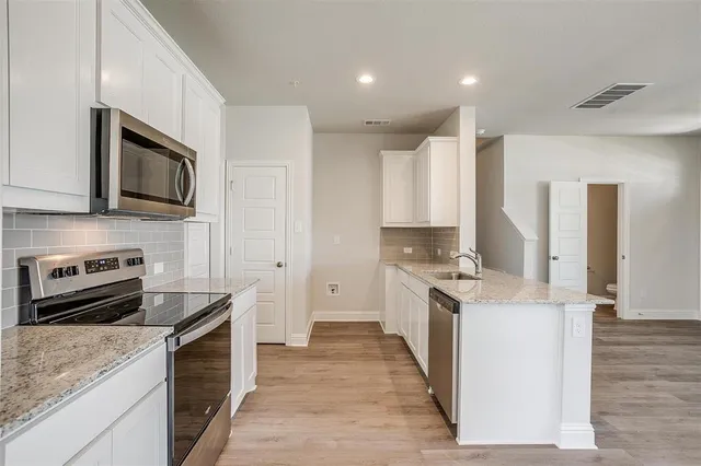 a kitchen with sink a microwave and cabinets