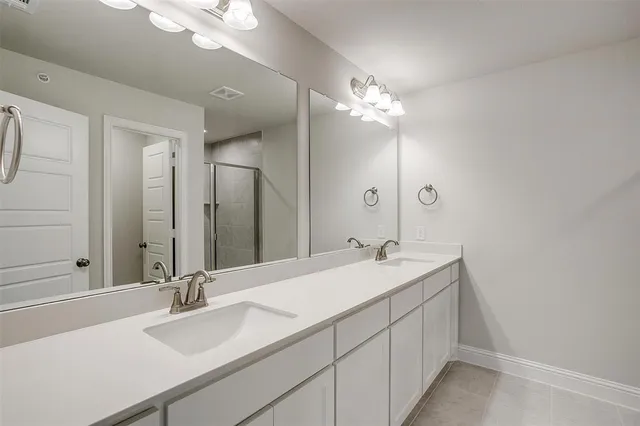 a bathroom with a double vanity sink and a mirror