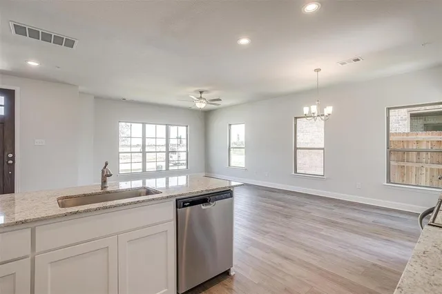 a kitchen with stainless steel appliances granite countertop a refrigerator and a sink