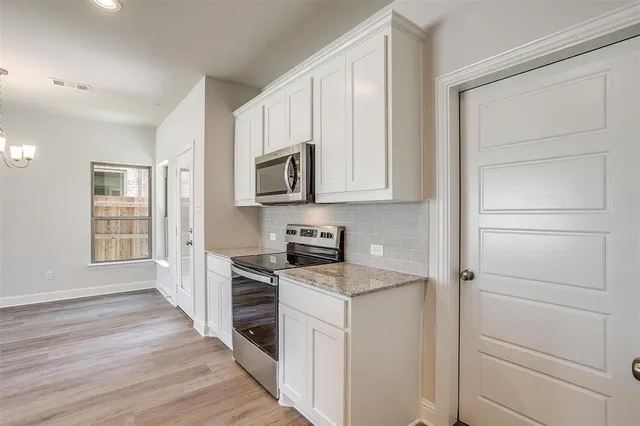 a kitchen with granite countertop a sink and dishwasher with wooden floor