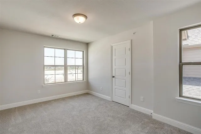an empty room with windows and closet