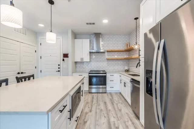 a kitchen with a refrigerator a sink and dishwasher a oven with wooden floor