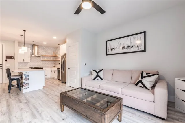a living room with furniture and kitchen view