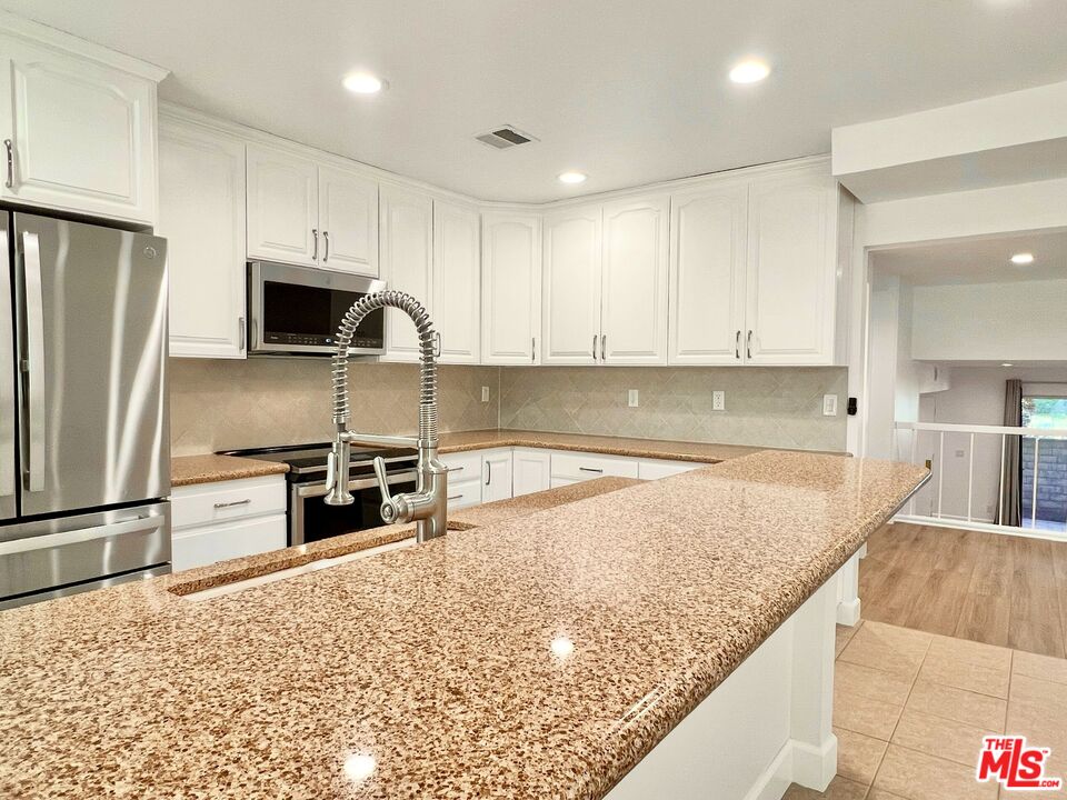 13218 Fiji Way, Unit B Marina del Rey, CA 90292 - Photo 22 of 63 a kitchen with granite countertop a refrigerator and a sink