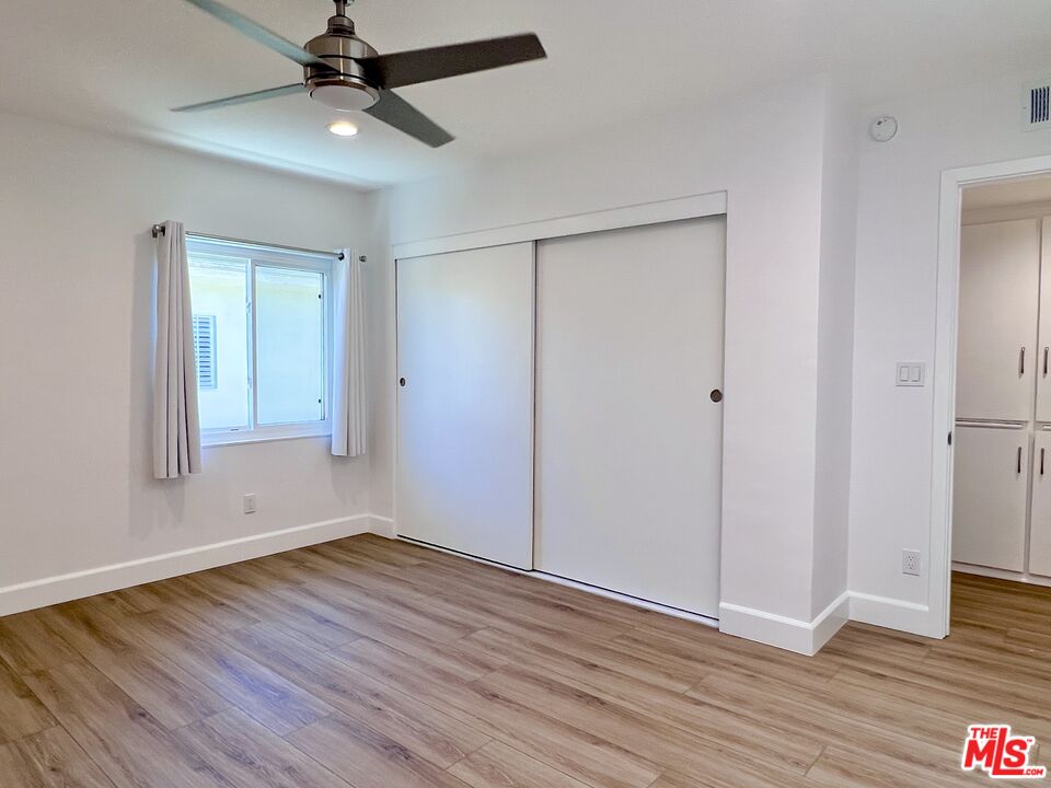 13218 Fiji Way, Unit B Marina del Rey, CA 90292 - Photo 44 of 63 an empty room with wooden floor a ceiling fan and windows