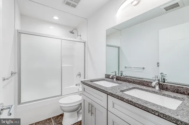 a bathroom with a granite countertop sink toilet and shower