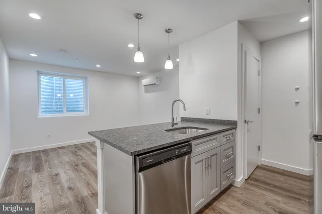 a kitchen that has a sink a stove and a wooden floor
