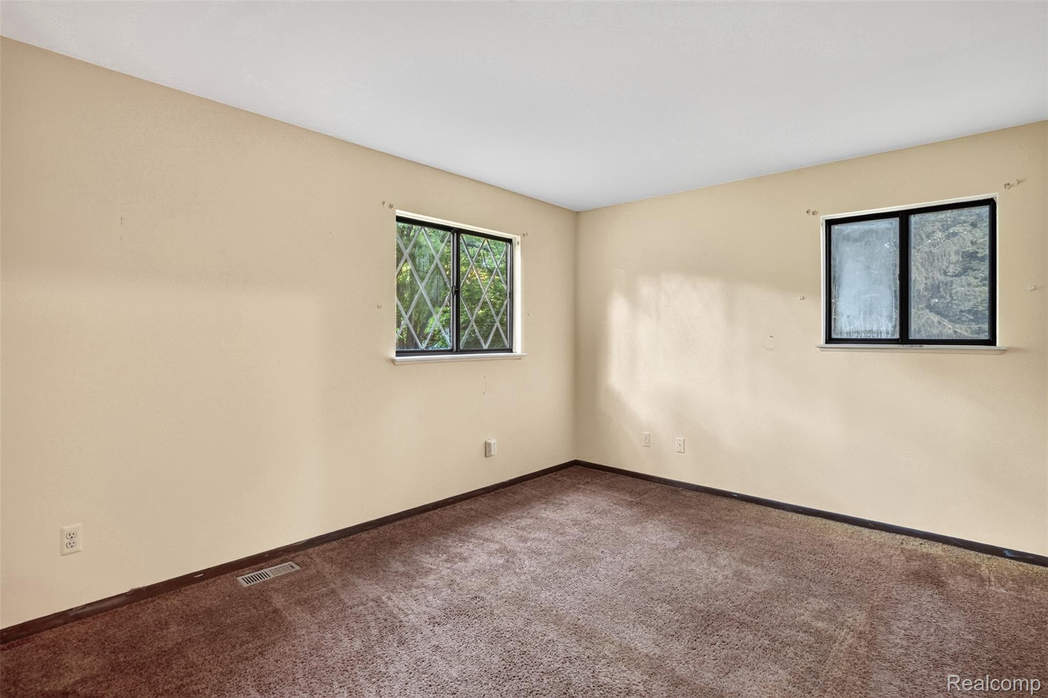 16955 English Road Manchester, MI 48158 - Photo 16 of 37 Carpeted room featuring a window with diamond-patterned grilles, a second window, light beige walls, and a white ceiling