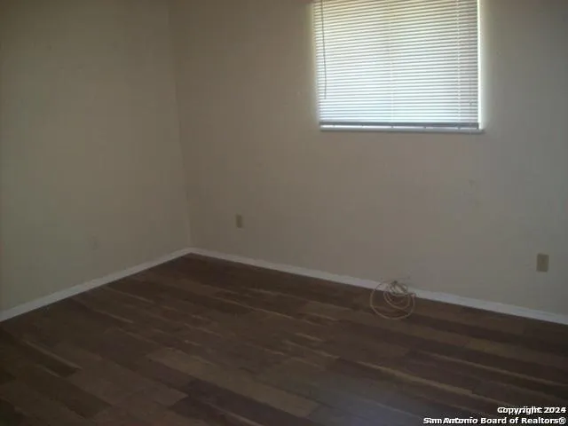 a view of a small space with wooden floor and a window