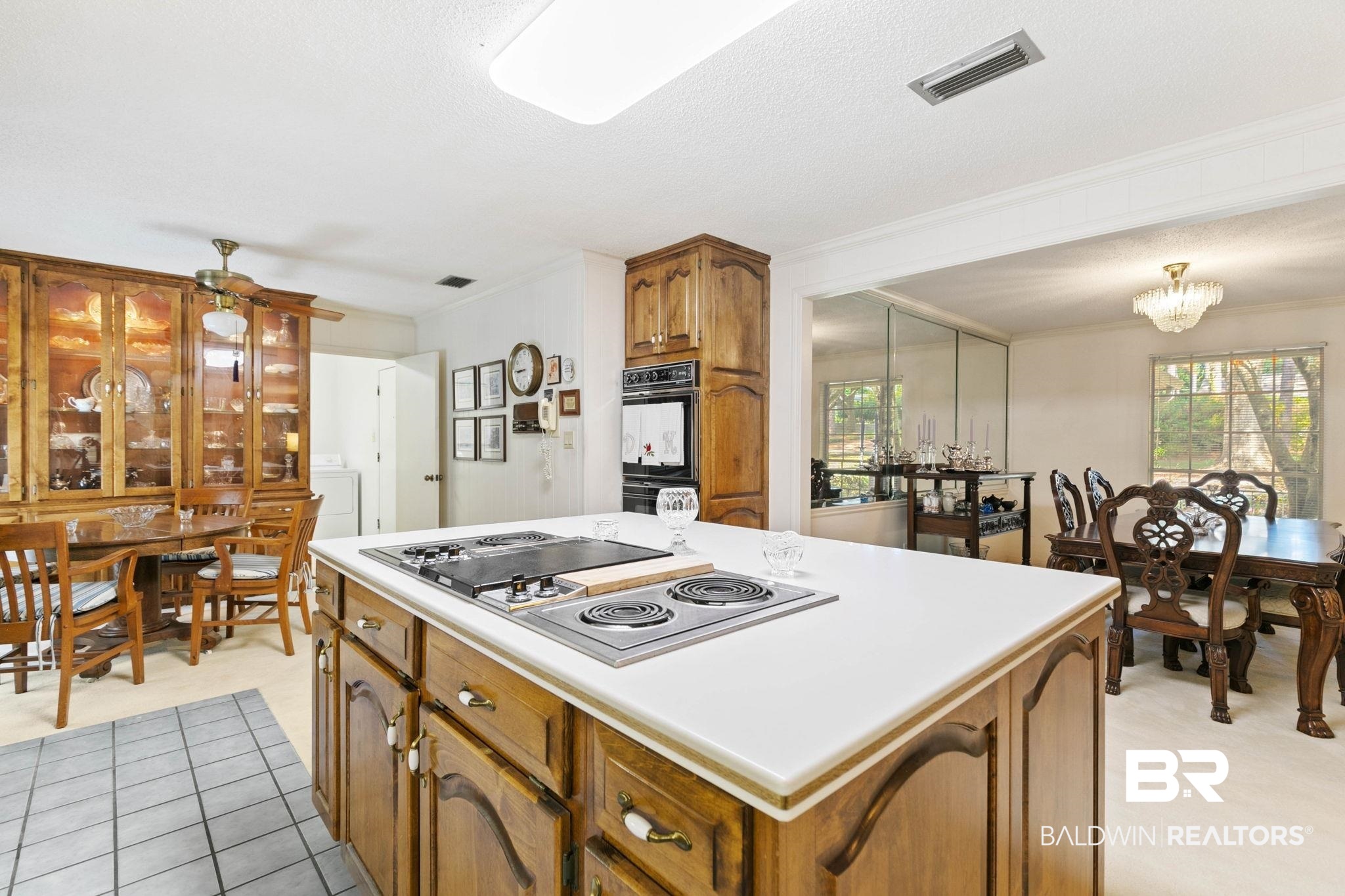 752 Evergreen Street Fairhope, AL 36532 - Photo 7 of 100 Kitchen featuring brown cabinets, a kitchen island, crown molding, stainless steel electric stovetop, and plenty of natural light