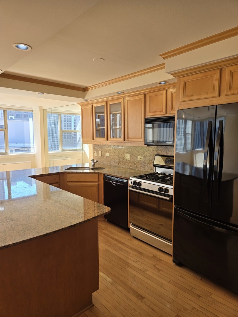 40 East Cedar Street, Unit 21C Chicago, IL 60611 - Photo 20 of 33 a kitchen with stainless steel appliances a stove refrigerator sink and cabinets
