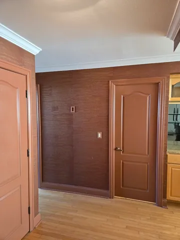 an empty room with wooden floor and closet area