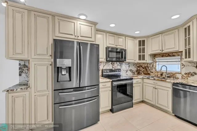a kitchen with cabinets stainless steel appliances and a window