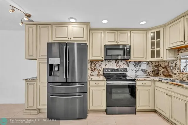 a kitchen with stainless steel appliances granite countertop a refrigerator stove and sink