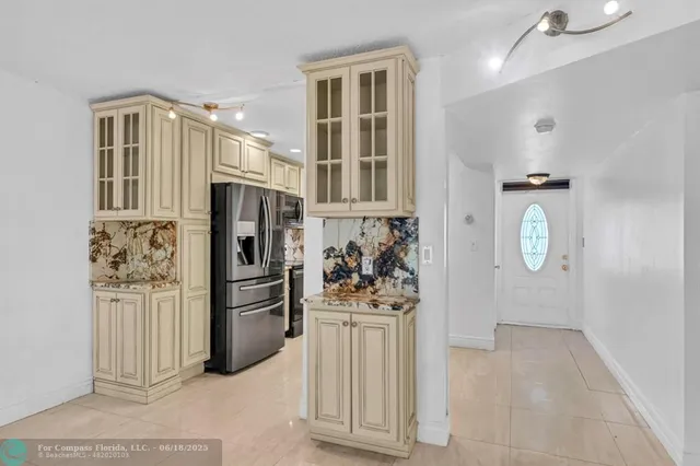 a kitchen with stainless steel appliances granite countertop a refrigerator and a stove top oven