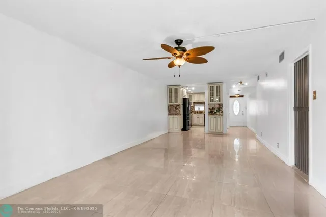 a view of a livingroom with a chandelier furniture and a ceiling fan