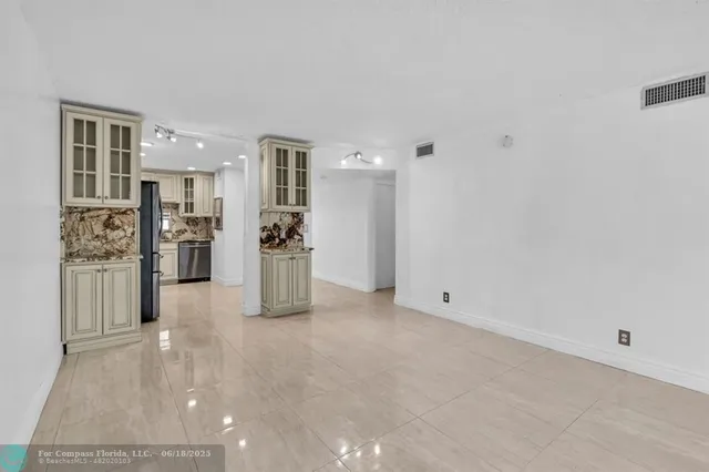 a view of a kitchen with refrigerator and windows