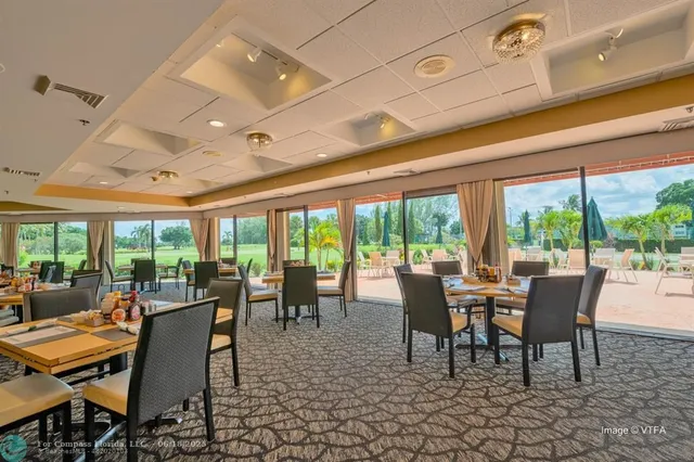 a view of a dining room with furniture large windows and wooden floor