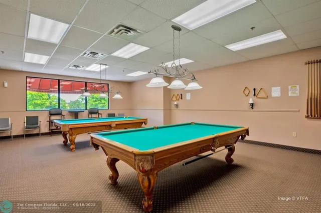 a room with pool table and windows