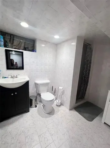 a bathroom with a toilet sink and mirror