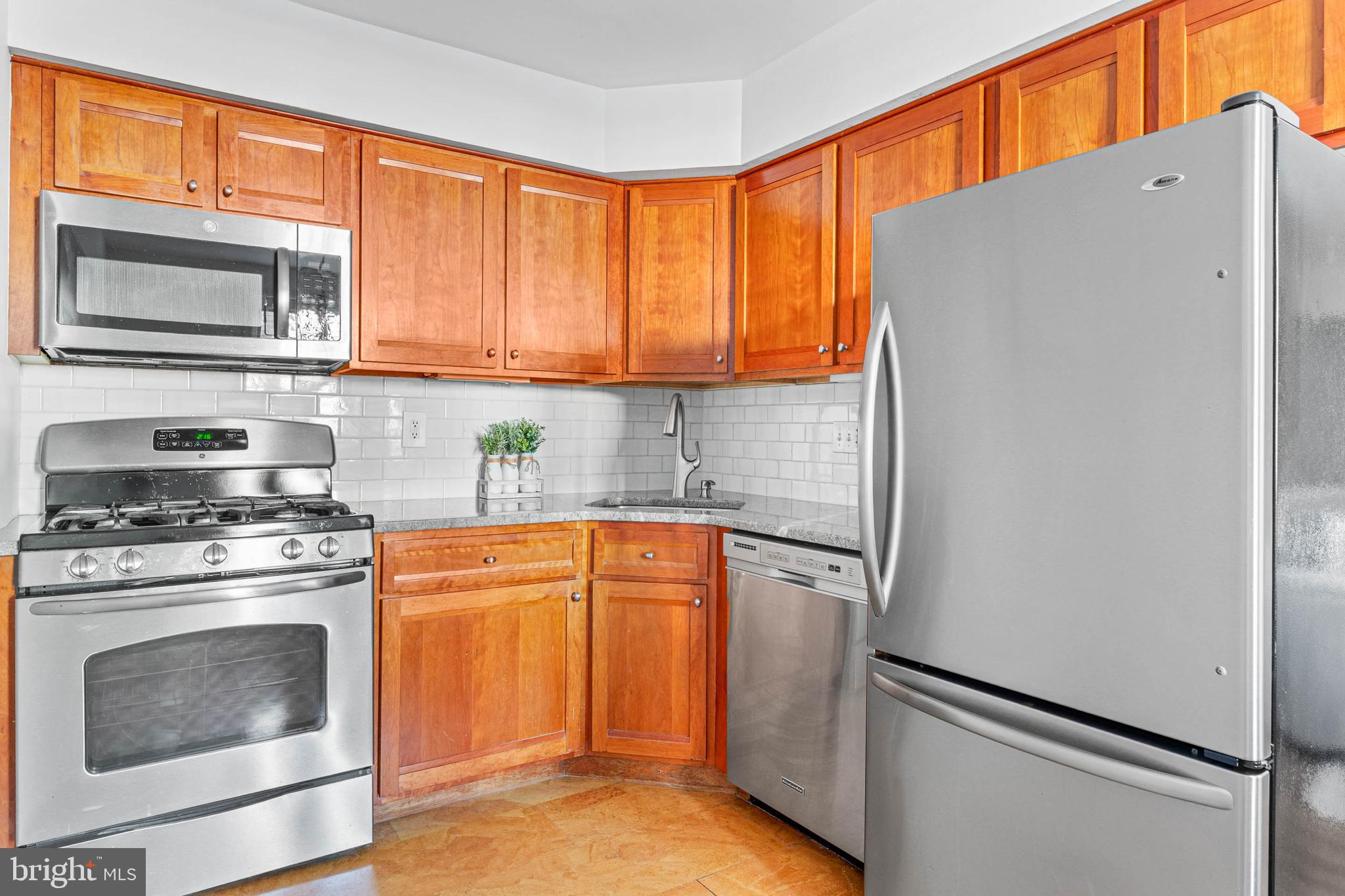 383 Lakeside Road, Unit 105 Ardmore, PA 19003 - Photo 7 of 25 a kitchen with stainless steel appliances granite countertop a refrigerator and a stove top oven