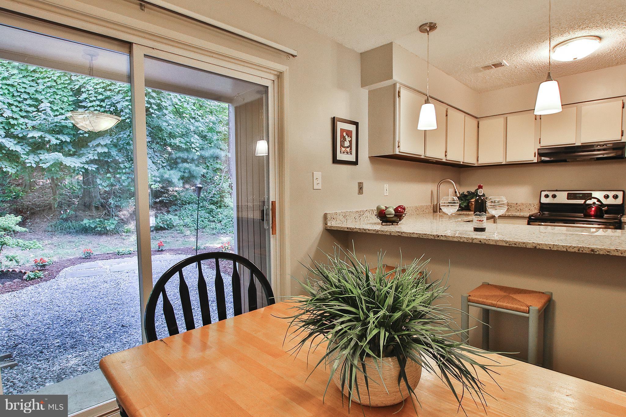2203 Coppersmith Square Reston, VA 20191 - Photo 10 of 25 a kitchen with stainless steel appliances granite countertop a refrigerator a sink a stove and a wooden floors