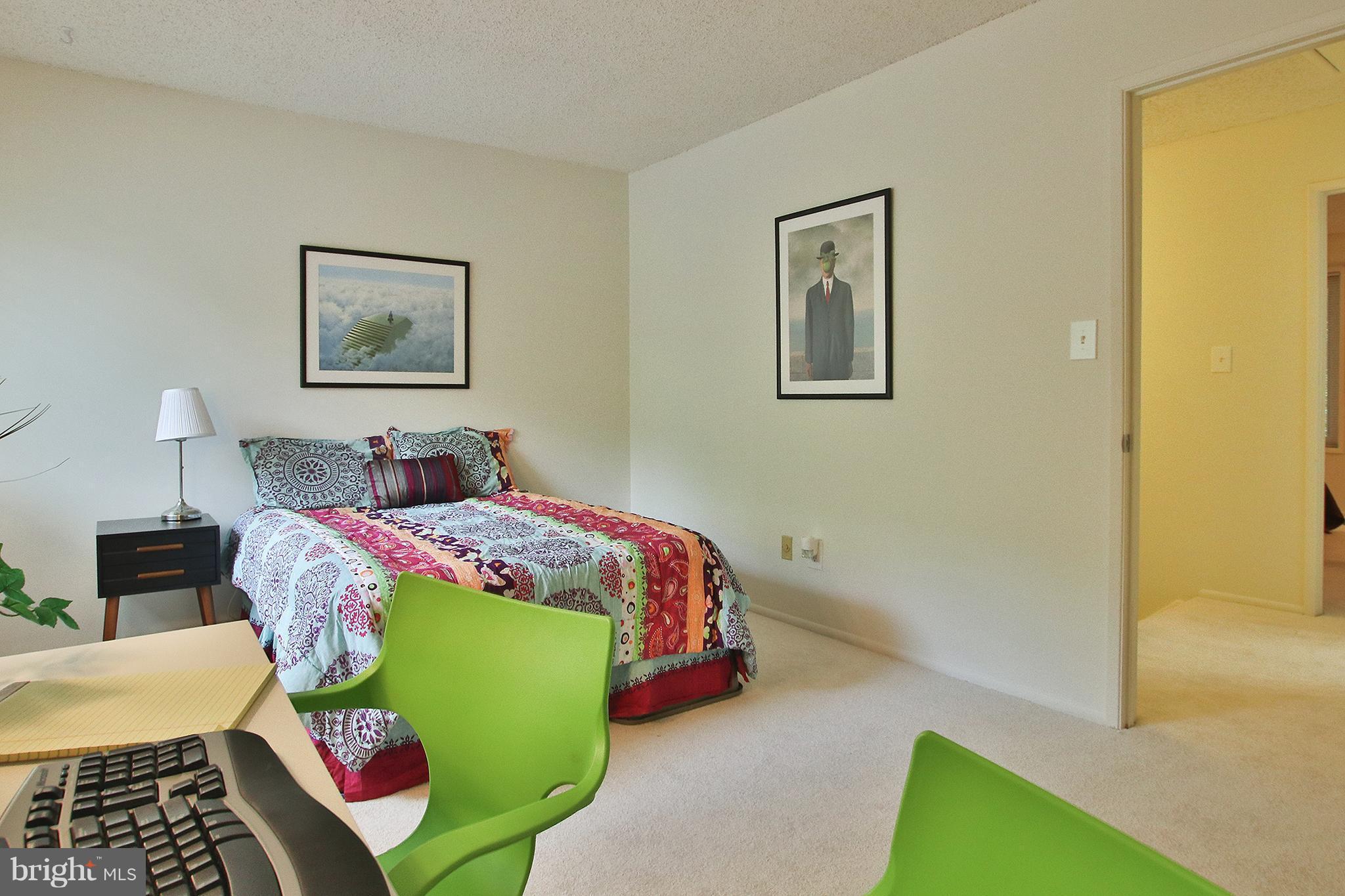 2203 Coppersmith Square Reston, VA 20191 - Photo 17 of 25 a bedroom with a bed and a lamp on dresser