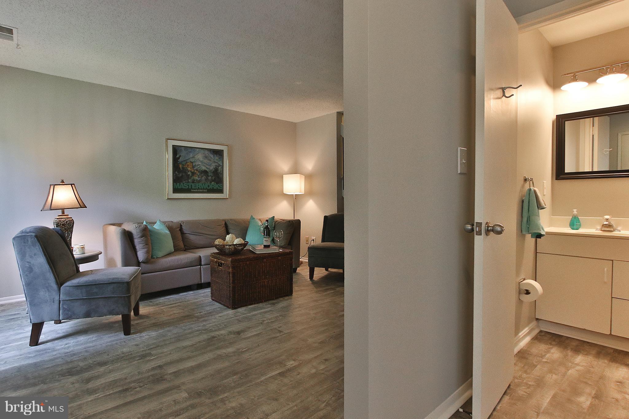 2203 Coppersmith Square Reston, VA 20191 - Photo 3 of 25 a living room with furniture a lamp and a window