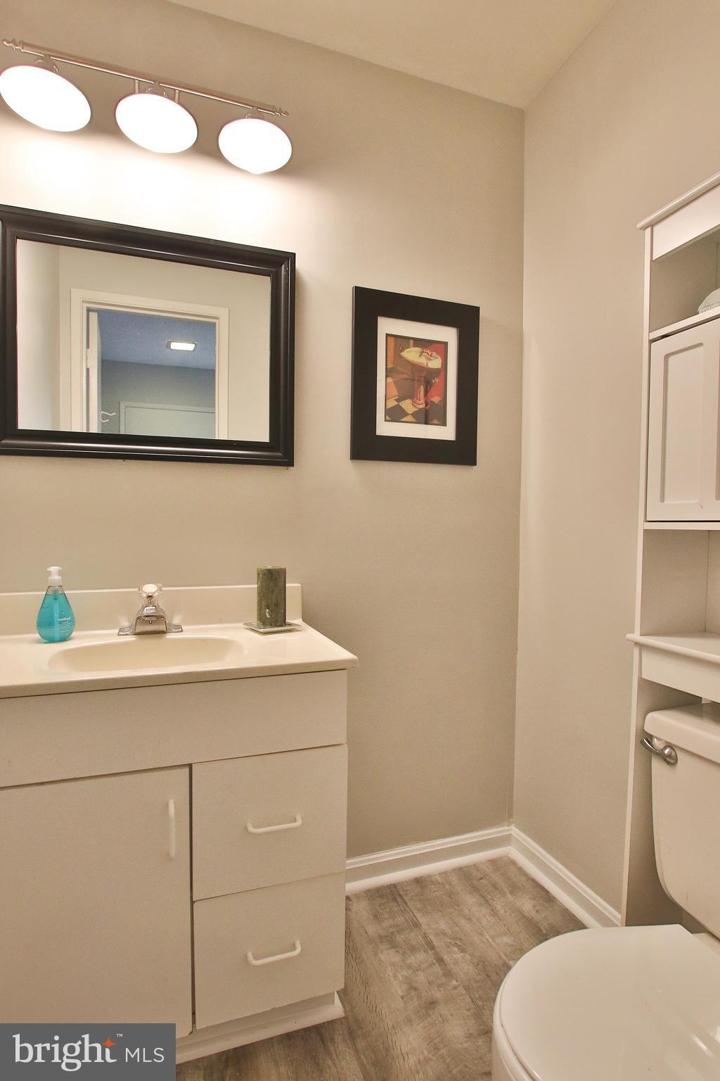 2203 Coppersmith Square Reston, VA 20191 - Photo 4 of 25 a bathroom with a toilet sink and mirror