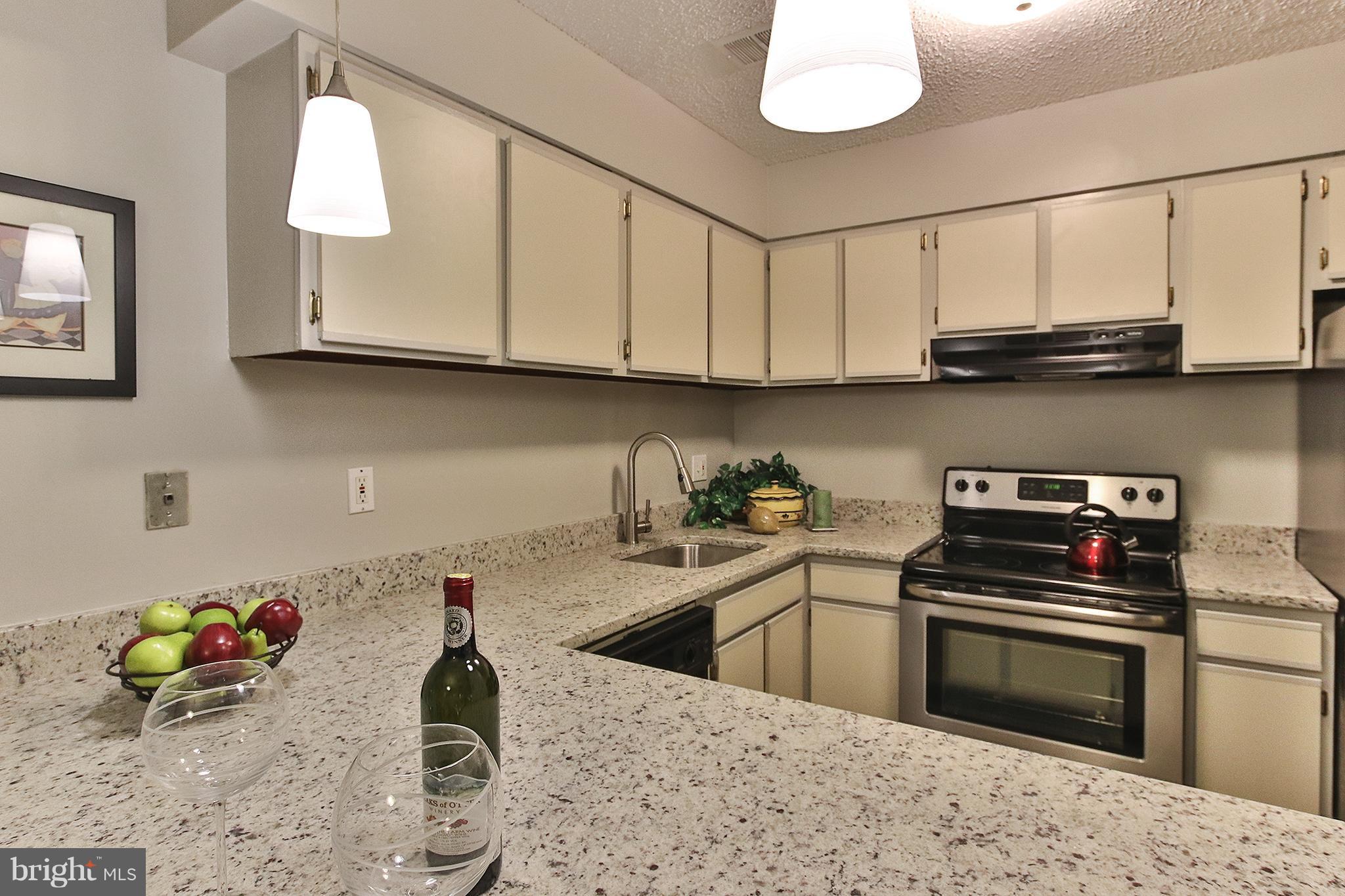 2203 Coppersmith Square Reston, VA 20191 - Photo 8 of 25 a kitchen with stainless steel appliances granite countertop a sink stove and cabinets