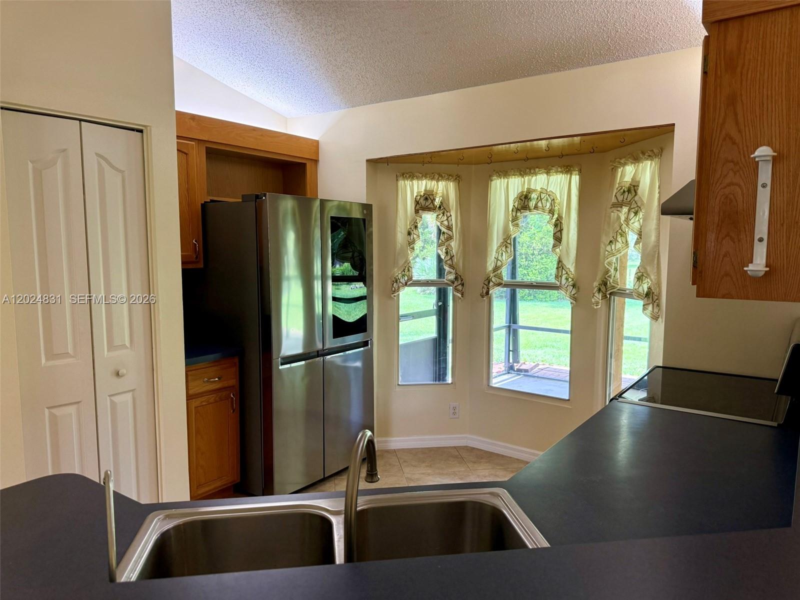 15819 76th Road North Loxahatchee, FL 33470 - Photo 32 of 45 a kitchen with a refrigerator and a view of living room