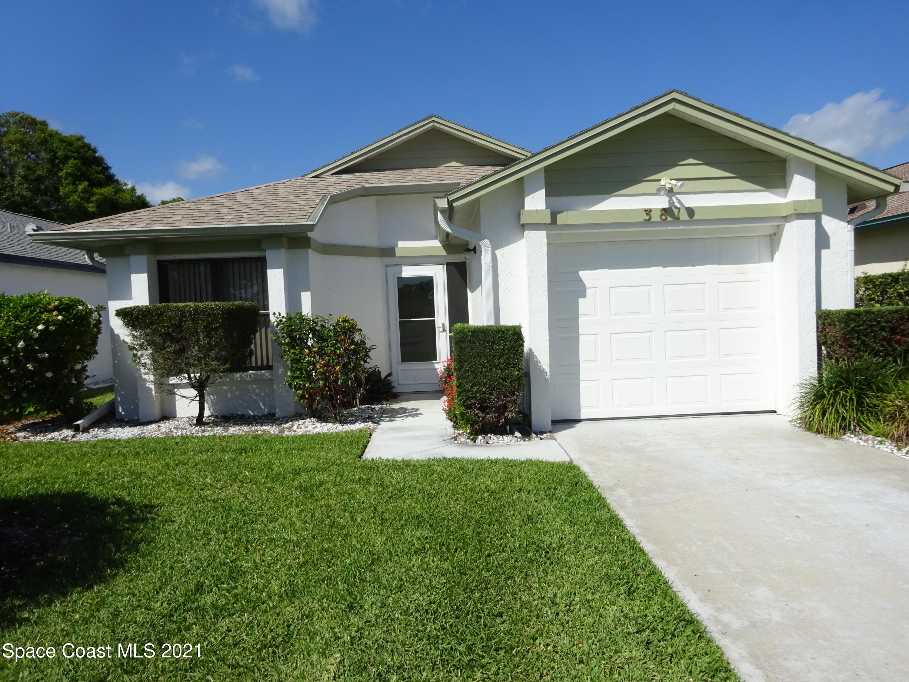 381 Myrtlewood Road Melbourne, FL 32940 - Photo 2 of 31 a front view of a house with a yard and garage